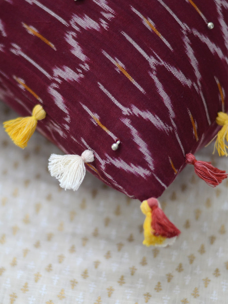 Prosperity Cushion Cover (Maroon), a unique hand embroidered cotton cushion cover with soundless ghungroo and tassel detailing from our wide range of quirky, bohemian home decor products like ethnic cushion covers, thread art and more.